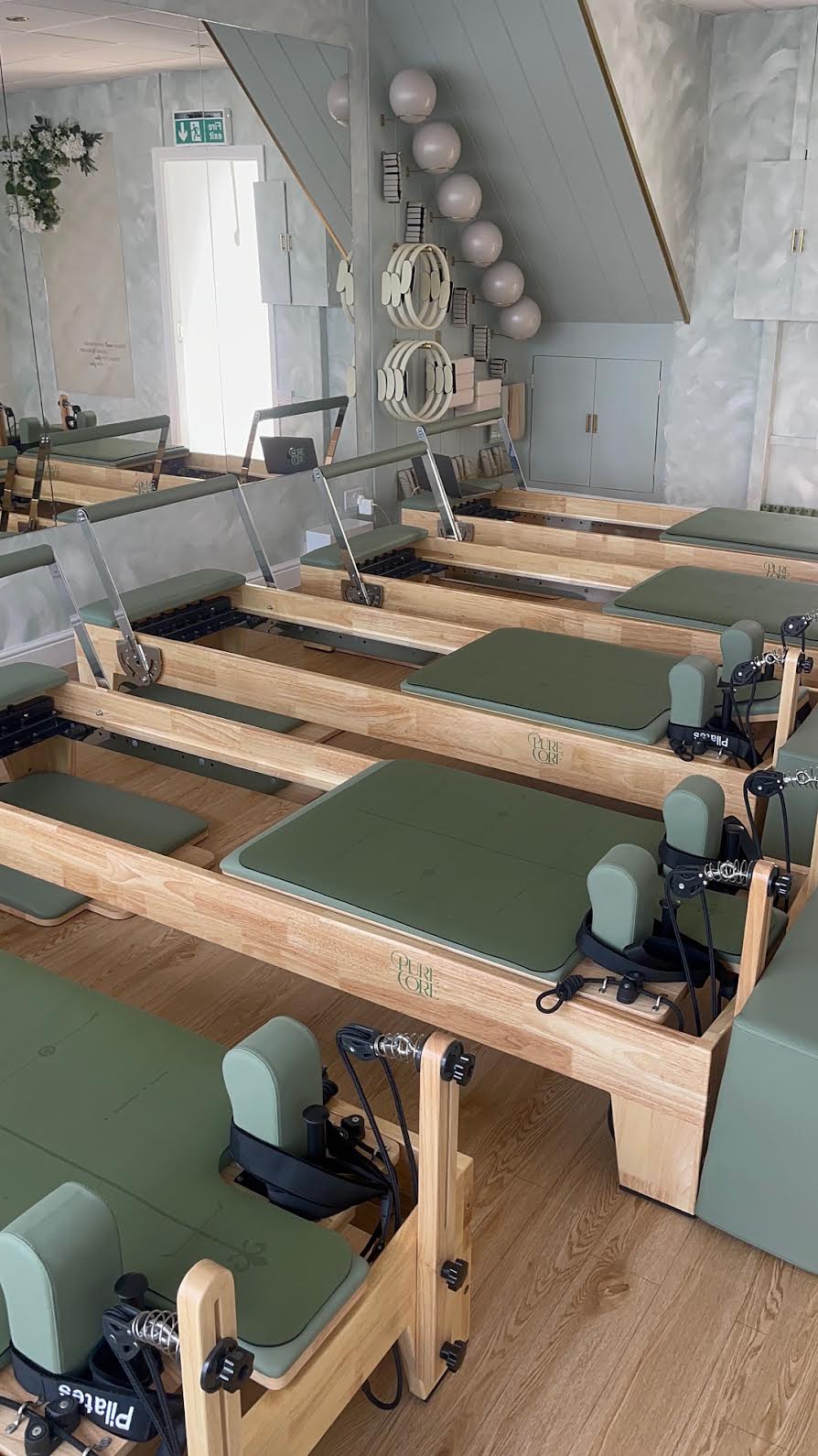 Row of Pure Core reformers with sage upholstery in the Hamsey Green studio